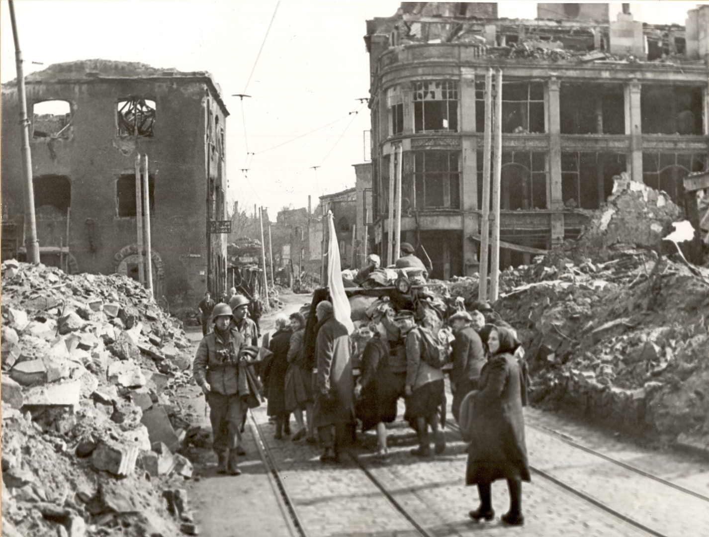 Bei ihrem Rundgang durch Darmstadt begegnen Lieutenant Kenneth Elk und Seargeant Peter Anders am Marktplatz befreiten polnischen Zwangsarbeitern. 