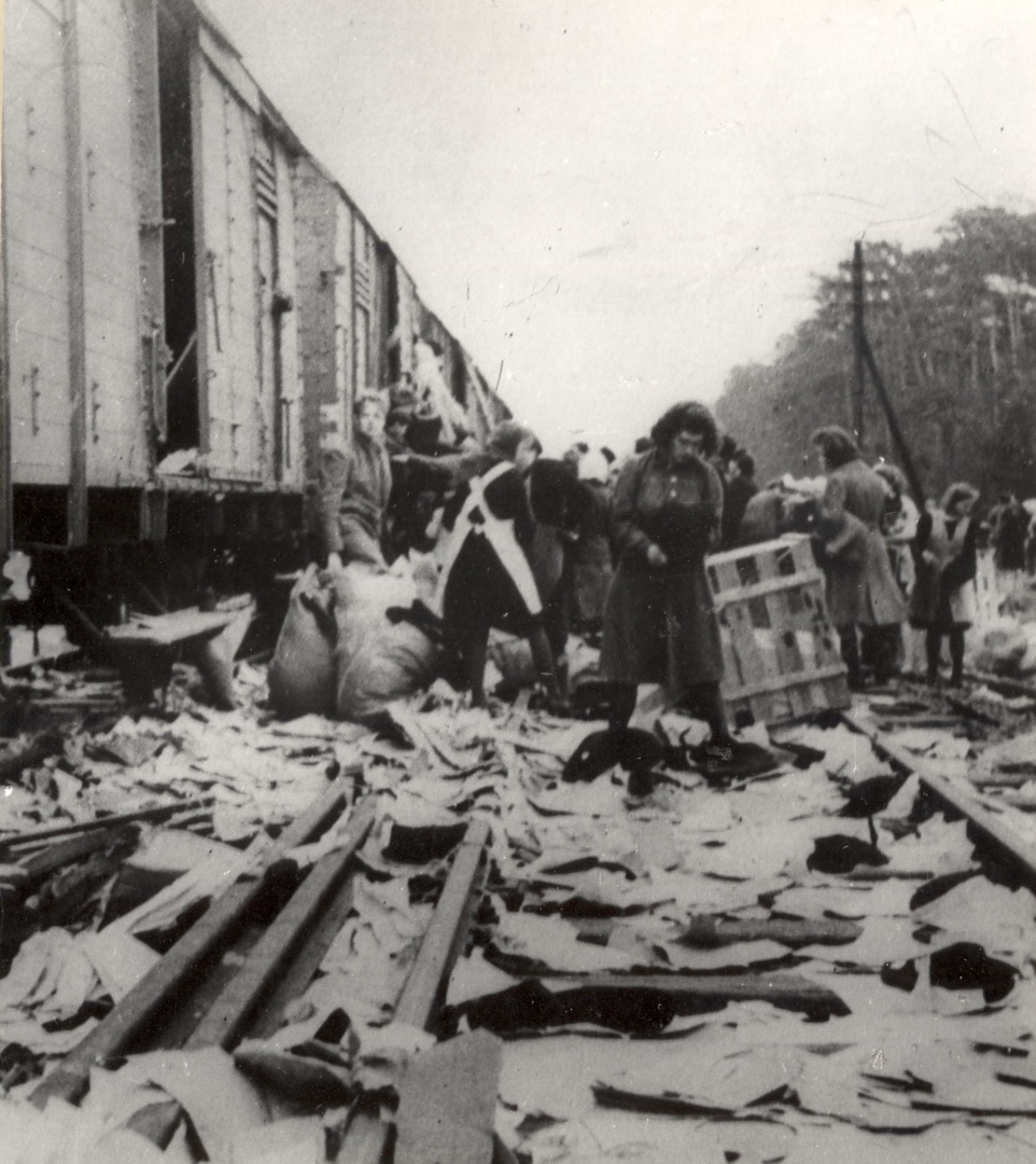 Nach dem Rückzug deutscher Truppen und vor der Etablierung einer amerikanischen Verwaltung nutzten die Bewohner:innen den „rechtsfreien Raum“ und brachen Güterzugwagen mit Kleidung auf.